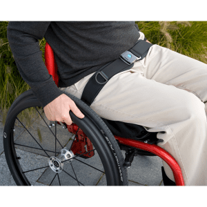 Wheelchair user secured with Bodypoint 2-Point Padded Hip Belt HB275 for mobility support outdoors.