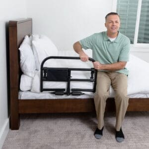 Man using Stander Prime Safety Bed Rail 8940 for home mobility and fall prevention support.