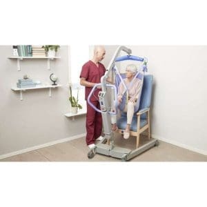Arjo Maxi 500 Floor Lift aids elderly mobility transfer in home care; healthcare worker assists.