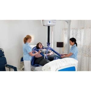 Arjo Maxi Sky 1000 Bariatric Ceiling Lift with blue sling assists patient transfer in hospital.