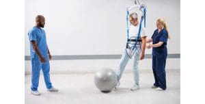 Man uses Arjo Loop Walking Sling harness for mobility support with assist, ideal for home care.