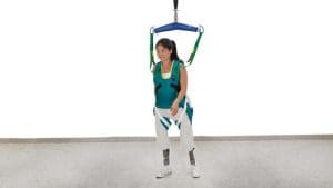 Arjo Loop Walking Jacket harness with overhead lift supports woman for mobility and home care.