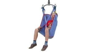 Pediatric blue sling lift for home care mobility support, suspended by mechanical hoist.