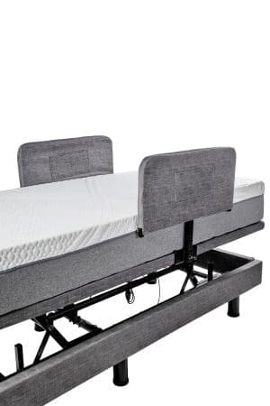 Adjustable medical bed frame with side rails for home care and mobility support.