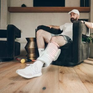 Man using HoMedics Modulair Compression Calf Wrap for at-home leg therapy and mobility support.